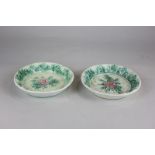 A pair of Majolica dishes with cabbage rose decoration on basket weave ground, 14cm diameter