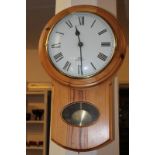 A Rowe Guernsey pine drop dial wall clock with Roman numerals on white enamel 9.5 inch dial