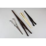 Four early 20th century glove stretchers, one with silver handles, one in ebony, one in ivory and