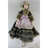 A European costume doll with painted cloth face and thread hair, the composite limbs on a filled