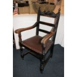 A carved oak framed carver chair with 'leather' seat on turned legs