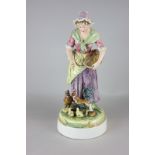 A Majolica figure of a woman feeding chickens, 34cm high