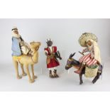 Three creche figures, all in leather, of an Arab riding a camel, a Mexican riding a donkey and an