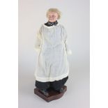 A 19th century composition priest doll with painted face, leather hands, wearing white cassock,