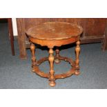 A George III style walnut circular occasional table with pie crust border, on turned legs and low