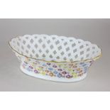 A porcelain basket weave chestnut dish with floral bocage detail, crossed sword mark to base,