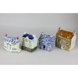 Three Staffordshire pottery money boxes modelled as houses, together with a Delftware pottery house