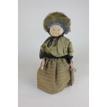 An early 20th century doorstop doll with painted fabric head, ceramic limbs (a/f), in original brown