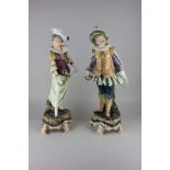 A pair of 20th century Majolica figures of a swashbuckling man and woman with rapiers and