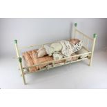 A mid 20th century folding doll's bed with linen, together with a 1940's plastic and cloth doll,