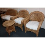 A wicker conservatory suite of two seater sofa, two armchairs and an occasional table with cream