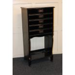 An ebonised music cabinet of five drawers over open shelf, 49cm