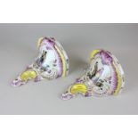 A pair of Continental porcelain wall brackets depicting scenes of lovers, with yellow and pink