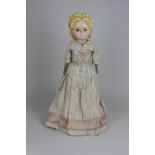 A Victorian wax over composition pumpkin head doll with moulded hair and pierced ears, brown glass