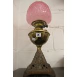 Lighting: Victorian oil lamp. Cast metal base, brass reservoir, burgundy glass shade & clear