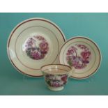 A porcelaineous cup, saucer and plate printed in pink and banded in lustre with a lakeland view,