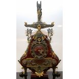 A RED MARBLE MANTLE CLOCK DECORATED WITH