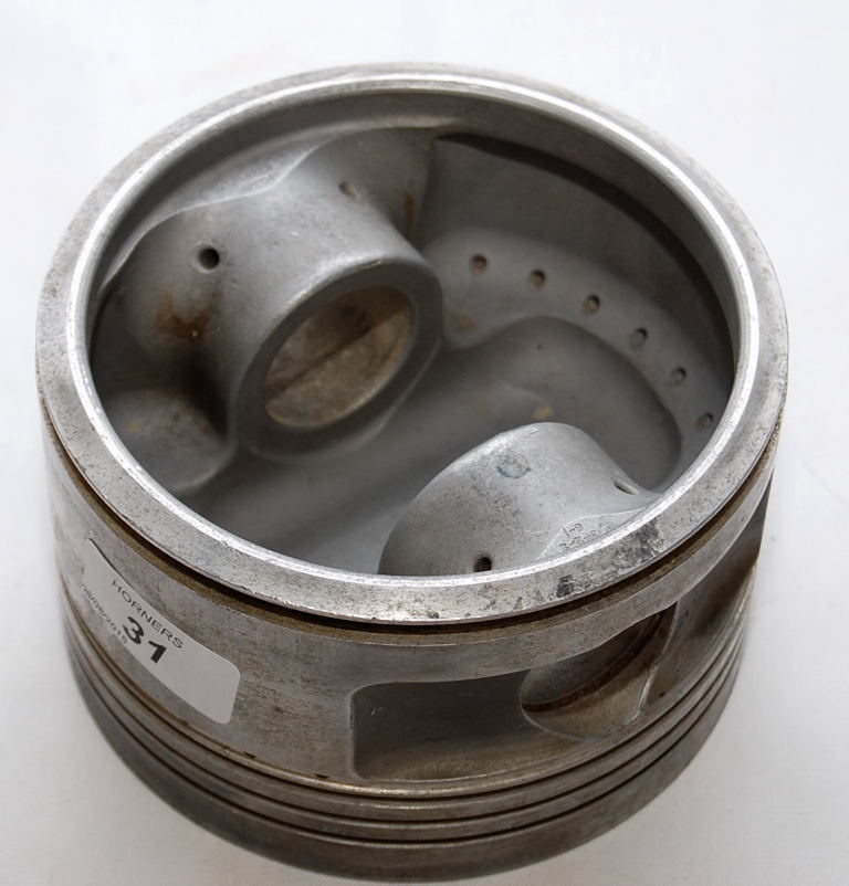 AN ALUMINIUM PISTON BELIEVED TO BE FROM
