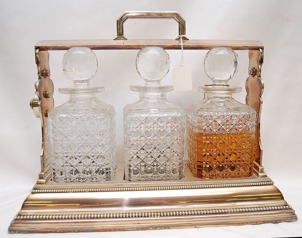 A THREE BOTTLE PLATED TANTALUS, THE DECA