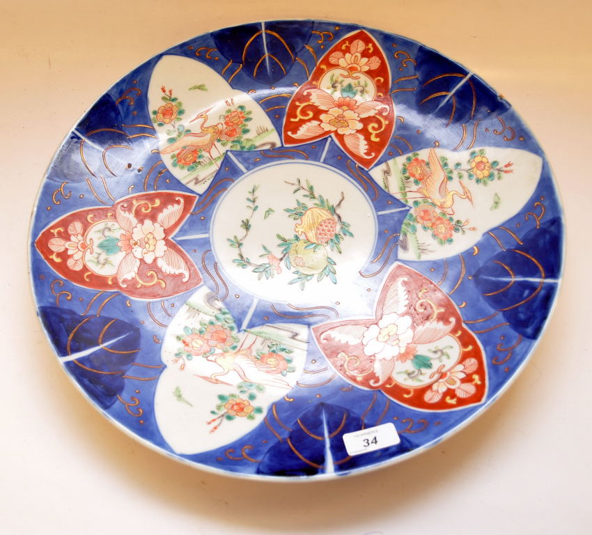 A LARGE JAPANESE IMARI PATTERN CHARGER DECORATED WITH STORK AND FLORAL PANELS IMPRESSED MARK TO