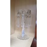 A single Edwardian clear glass table candlestick, having a facetted column and icicle lustre drops