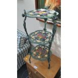 A cast iron green and florally painted three tier pot-plant stand