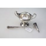 A George V silver bon-bon dish, having beaded rim and swept scrolled handles, on stepped circular