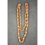 A amber necklace alternating with large and small faceted, individually knotted beads, largest