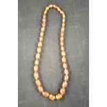 A reconstituted amber bead necklace comprising thirty-eight graduated beads (largest 22mm) -