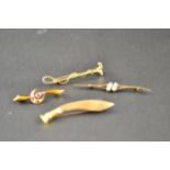 A yellow metal bar brooch in the form of a kukri, a 9ct gold bar brooch set with four white