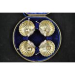 A cased set of four silver 'shell' salts, gilt interiors, two original spoons and two associated,