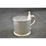 A late Georgian silver mustard with thumb piece and engraved stag monogram to lid, scroll handle,