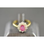 An 18ct gold ring set with central ruby surrounded by diamonds, size O 1/2 - approx gross weight 4.