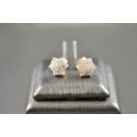A pair of 9ct gold stud earrings of floral form with pave set diamonds. CONDITION REPORT: Good