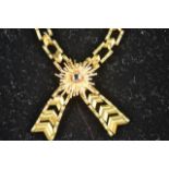 A 9ct gold 'chevron' link necklace of cross-over form, with applied starburst detail set with