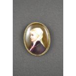 A porcelain brooch depicting young girl in traditional Flemish dress, in gold mount with scroll