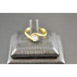 An 18ct gold ring with solitaire diamond, colour J, clarity SI, in cross-over setting, size I½,