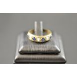 A yellow metal ring set with four sapphires and three white stones, size O1/2 - approx gross