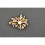 A yellow metal pearl and sapphire brooch in stylised floral form. CONDITION REPORT: Good condition.