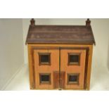 A late 19th/early 20th century dolls house of tongue and groove construction, front enclosed by a