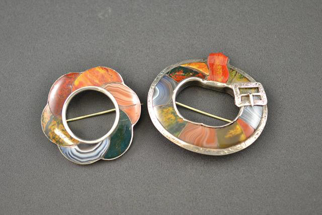 A white metal garter brooch mounted in sections with agates of varying colours - W6.5cm, together