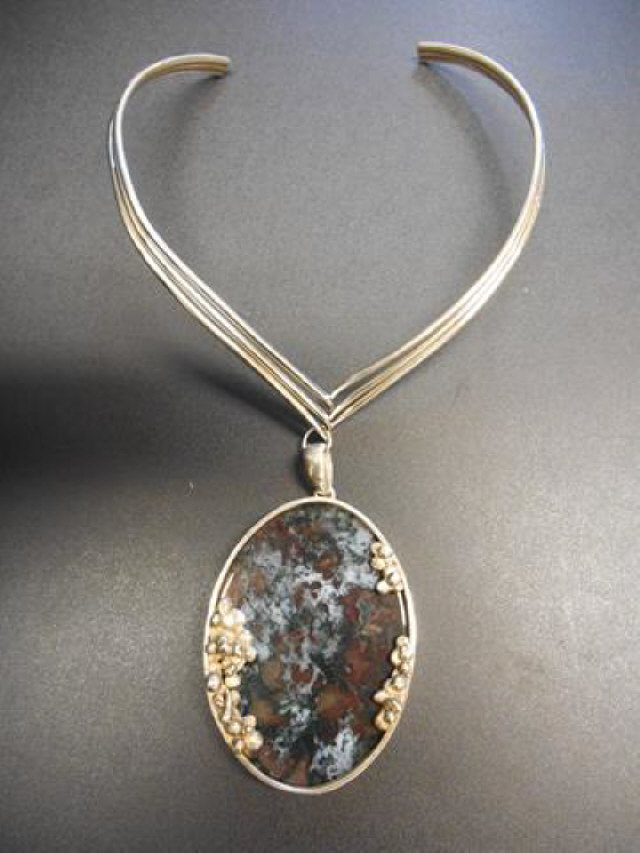 A handcrafted silver mounted agate pendant suspended on silver collar