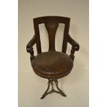 A late 19th/early 20th century walnut framed ship's revolving armchair, on ornate cast iron base