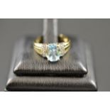 A 9ct gold ring with oval blue topaz and diamond set shoulders - size J. CONDITION REPORT: Good