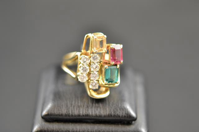 A 14k gold ring set with seven diamonds and three tourmaline in 1970s style abstract design - size
