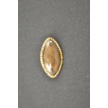 A marquise shaped yellow metal mourning brooch mounted with plaited hair bordered by pearls -