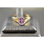 A 9ct gold ring set with oval amethyst flanked by two small diamonds - size N 1/2. CONDITION REPORT: