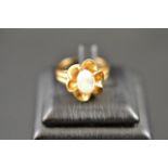 A 14k gold ring with central cabochon water opal in floral setting - size O CONDITION REPORT: Slight