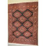 A Middle Eastern black ground rug with guls to centre surrounded by multiple border - 190x140cm