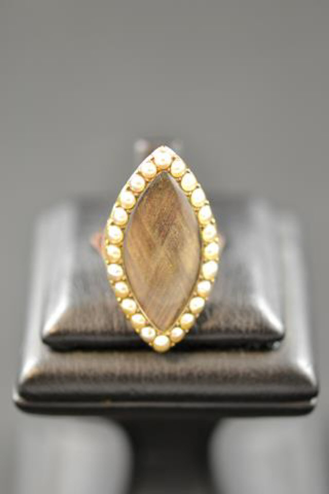 A Georgian yellow metal marquise shaped mourning ring with woven hair panel bordered by twenty